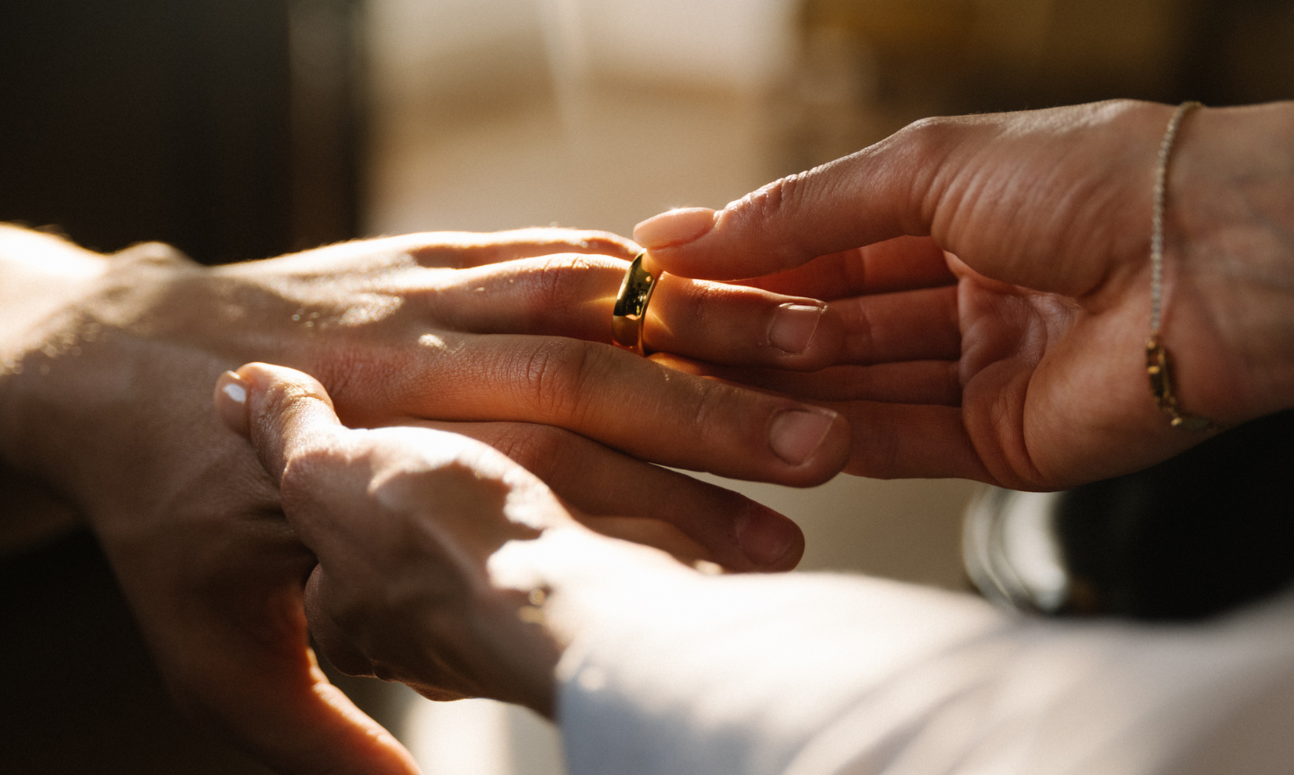 Bride placing the grooms wedding ring on his finger
