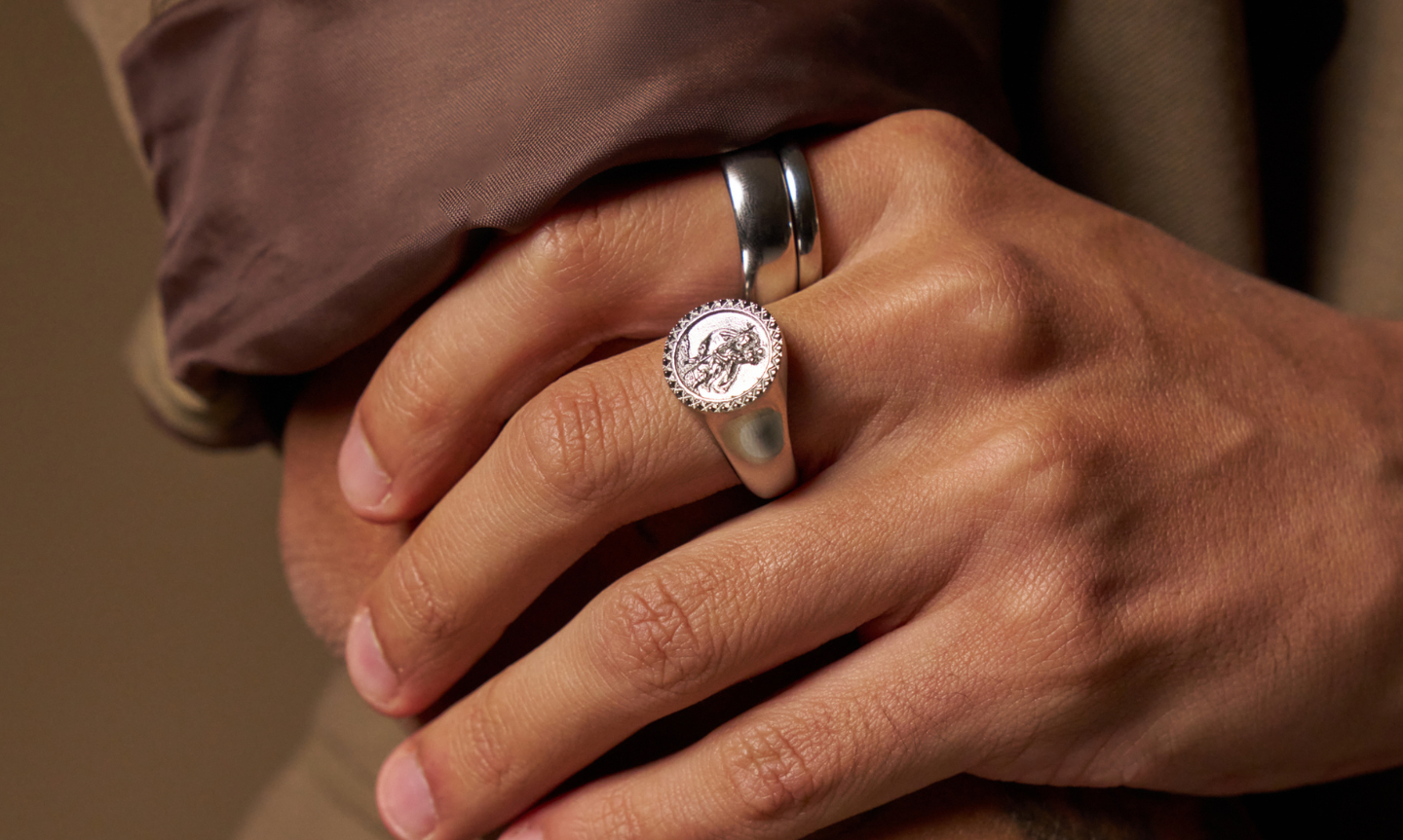 Man's hand wearing a tungsten and titanium wedding band in silver