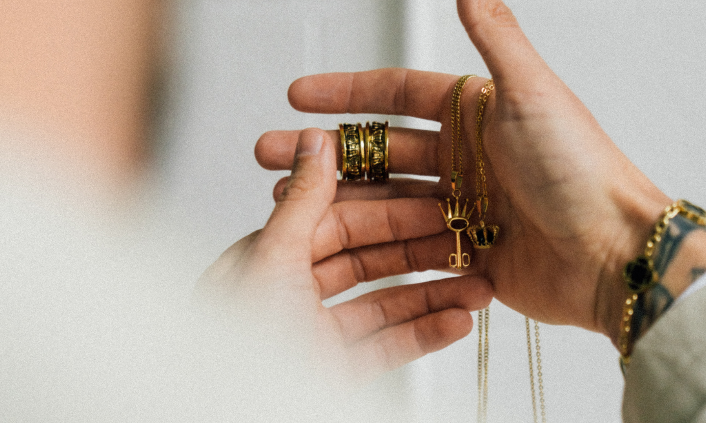 close up of man holding symbolic gold jewellery 
