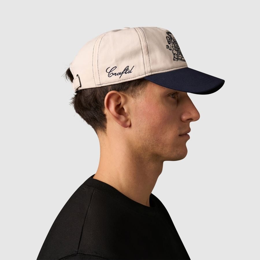 Model wearing the cream and navy cap, side view